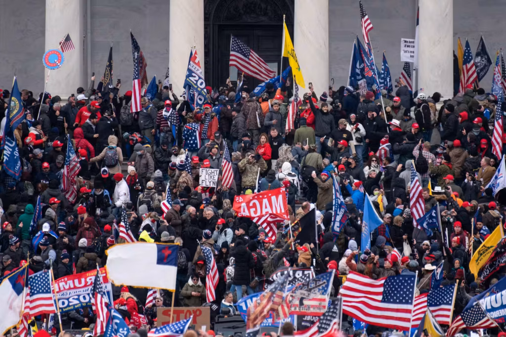 Rioters taking over the steps of a large, columned building.